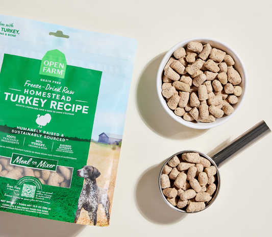 Open Farm Homestead Turkey Recipe dog food packaging with a bowl and scoop of pet food on a light background