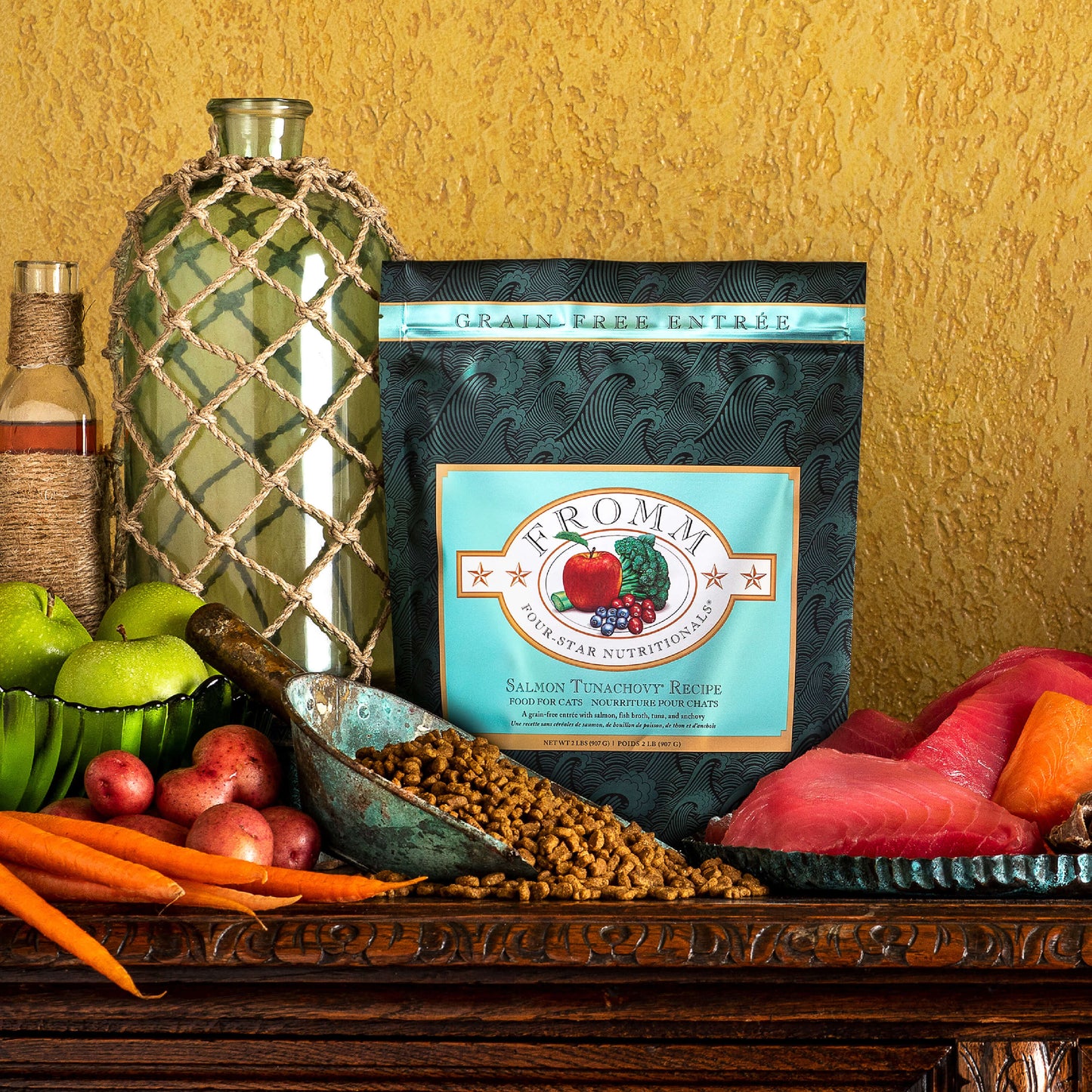 Bag of Fromm Salmon Tunachovy cat food on a table with fruits and vegetables
