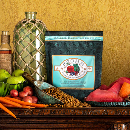 Bag of Fromm Salmon Tunachovy cat food on a table with fruits and vegetables
